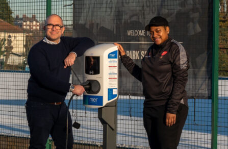 Man and Woman Standing by Mer EV Charging Point