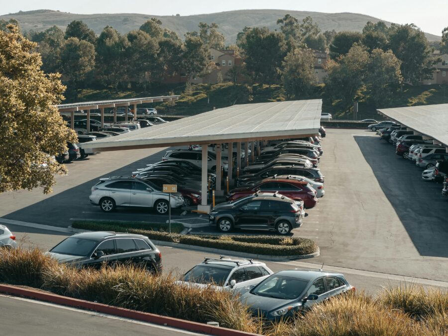 Cars parked under a sun canopy in a car park