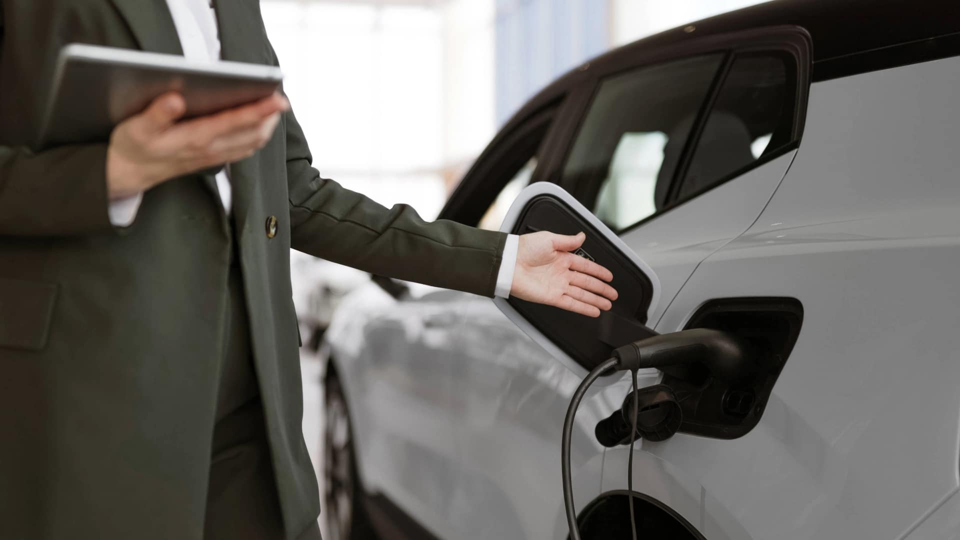 Sales person pointing to electric vehicle