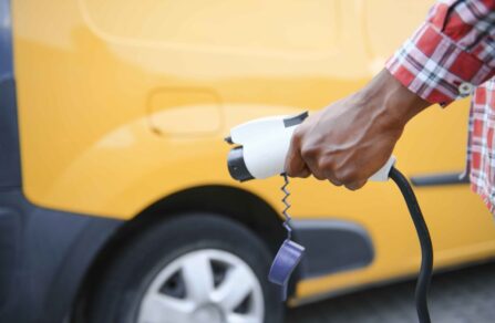 Man plugging an EV van into an EV charger.